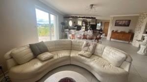 een woonkamer met een witte bank en een keuken bij Maison de standing avec vue à couper le souffle ! in Molles