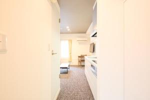 a hallway with a kitchen and a dining room at Hotel Stripe Sapporo - Vacation STAY 20494 in Kita-rokujō