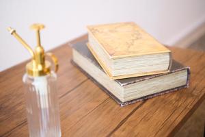 drie boeken op een tafel naast een fles bij Hotel Stripe Sapporo - Vacation STAY 20492 in Kita-rokujō +4 foto's