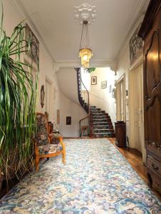 a living room with a chair and a staircase at VILLA ILIXON - Appartements privés proche du centre de Luchon, parking, billard, jardin in Luchon