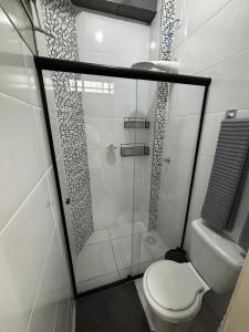 a bathroom with a glass shower with a toilet at Apartamento Estúdio em Volta Redonda - RJ in Volta Redonda