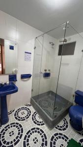 a bathroom with a shower and a blue toilet at El Gran Hotel in Chiquinquirá