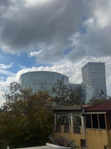 ein großes Glasgebäude mit einem hohen Gebäude im Hintergrund in der Unterkunft Elysee in Tirana