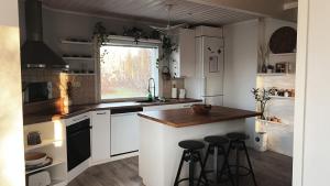 a kitchen with white cabinets and a counter with stools at Winter Wonderland Home in Rovaniemi