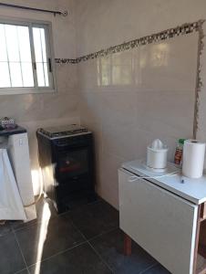 a kitchen with a stove and a counter with a window at Casa en punta N a 12 minutos de Piriapolis in Punta Colorada