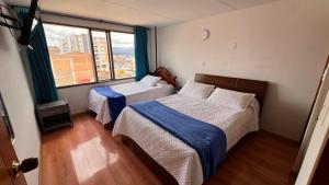 a bedroom with two beds and a large window at El Gran Hotel in Chiquinquirá
