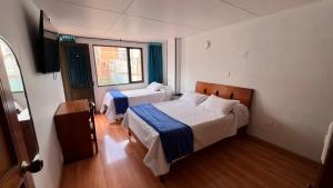 a bedroom with two beds and a window at El Gran Hotel in Chiquinquirá +10 photos
