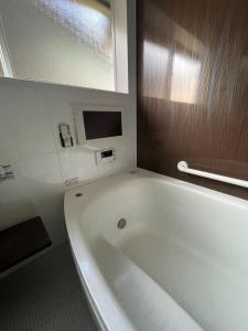 a white bath tub in a bathroom with a window at Tawaraya-Traditional Japanese-style Inn - Vacation STAY 73840v in Shimo-tahara +12 photos