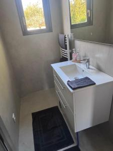 een witte badkamer met een wastafel en een spiegel bij Loveroom Montargis in Montargis