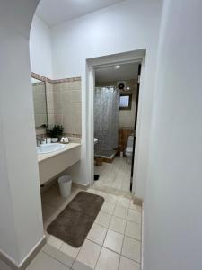 a bathroom with a sink and a tub and a toilet at Cosy Private Suite in Suwādah