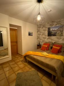 a bedroom with a bed and a stone wall at Gîte Le Sirocco Meublé de tourisme 4 étoiles Le Moulin de Prédelles in Reillanne