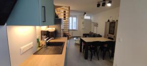a kitchen and dining room with a sink and a table at La 62 du 11 11 in Bourbourg