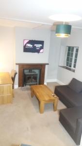 a living room with a couch and a table and a tv at Yew Tree Cottage in Bristol