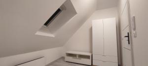 ein kleiner weißer Raum mit einem Oberlicht in der Decke in der Unterkunft La 62 du 11 11 in Bourbourg