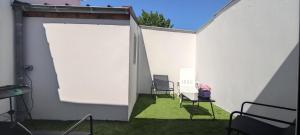 an open door in a white wall with chairs at La 62 du 11 11 in Bourbourg