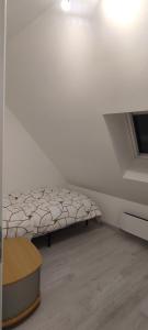 ein weißes Zimmer mit einem Bett und einem Fenster in der Unterkunft La 62 du 11 11 in Bourbourg