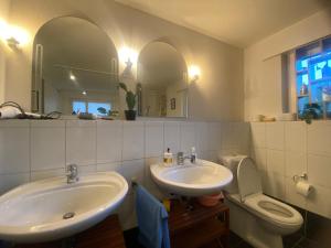 a bathroom with two sinks and a toilet and a mirror at Stay Inn - Meisterschwanden in Meisterschwanden +14 photos