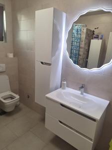 BeogradにあるWelcome dear guests!の洗面台と鏡のある白いバスルーム