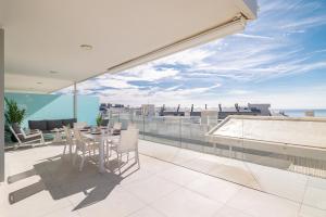 a balcony with a table and chairs on a roof at Med2holidays in Fuengirola