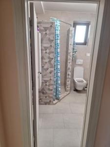 BeogradにあるWelcome dear guests!のトイレとシャワーカーテン付きのバスルーム