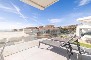 a balcony with a bench and a view of the city at Med2holidays in Fuengirola
