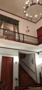 Dos imágenes de un pasillo con una escalera y una lámpara de araña. en Villa Manolita, en Fuensanta