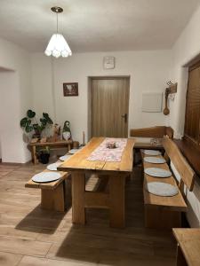 a dining room with a wooden table and benches at Chata Chotár Nová Baňa in Veľká Lehota