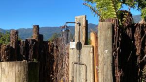 a wooden fence with a thermos on top of it at Alpacas Off Grid - Treehouse and Hut in Upper Takaka