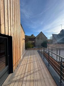 a wooden walkway next to a building at Maison Popeline in Les Andelys