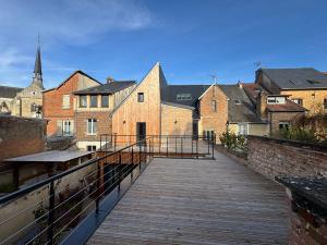 a wooden bridge over a city with buildings at Maison Popeline in Les Andelys