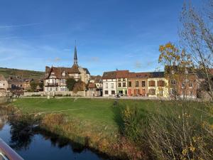a large building with a church and a river at Maison Popeline in Les Andelys +7 photos