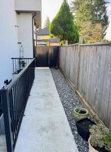 a fence and a walkway in front of a house at Excellent Place to Stay in Coquitlam