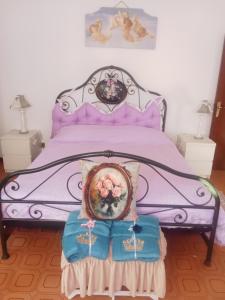 a purple bed with a picture of flowers on it at Villa Rosa in Acqualagna