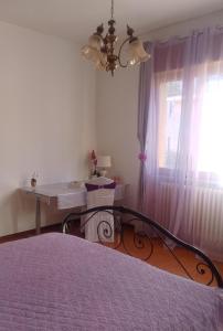 a bedroom with a bed and a desk and a window at Villa Rosa in Acqualagna