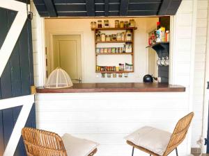 a bar in the back of a house with two chairs at Iguane Bungalow in Saint-François