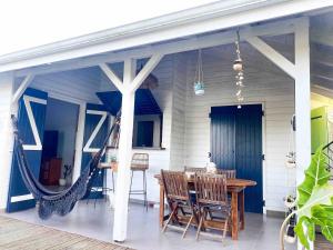a porch with a table and chairs on a house at Iguane Bungalow in Saint-François