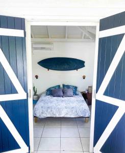 a bedroom with a bed with a surfboard on the wall at Iguane Bungalow in Saint-François