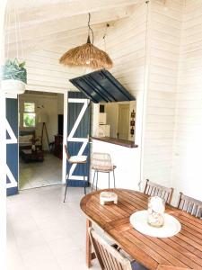 a porch with a wooden table and chairs at Iguane Bungalow in Saint-François