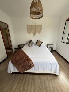 een slaapkamer met een groot wit bed in een kamer bij Wakana Ecosuits in Apulo +7 foto's