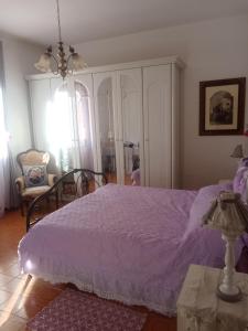 a bedroom with a purple bed and a chair at Villa Rosa in Acqualagna +18 photos