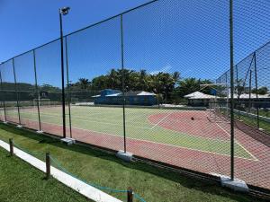 a tennis court with a net on a tennis court at Casa 10 com piscina em Jacuípe - Guarajuba in Camaçari