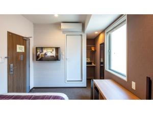 een kamer met een bed en een badkamer met een raam bij Hotel Reference Reisen - Vacation STAY 76456v in Fukuoka