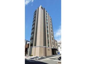 een hoog gebouw op een straat met een blauwe lucht bij Hotel Reference Reisen - Vacation STAY 76456v in Fukuoka
