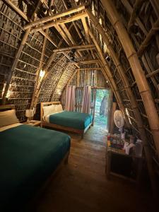 a bedroom with two beds in a bamboo house at Casa Lorette in Martínez
