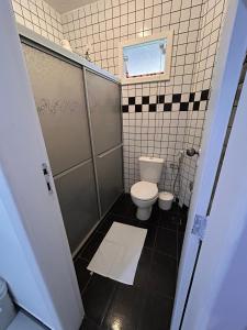 a small bathroom with a toilet and a shower at Casa com piscina no Cond Canto do Sol - Jacuípe - Guarajuba in Camaçari