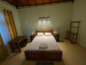 a bedroom with a bed with shoes on it at Elegance Cottage in Dagonna