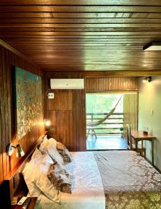 a bedroom with a large bed with wooden walls at Bela Vista Lodge in Novo Airão