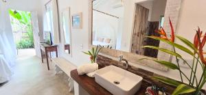 a bathroom with a sink and a mirror at Vila Pitanga Trancoso in Trancoso