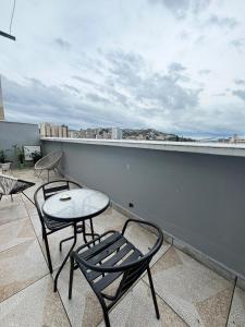 a patio with two chairs and a table on a balcony at APTO 401 - no centro, pertinho de tudo in Poços de Caldas