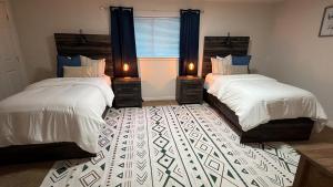a bedroom with two beds and a window with two lamps at Cozy and well located 2-bedroom basement in Provo